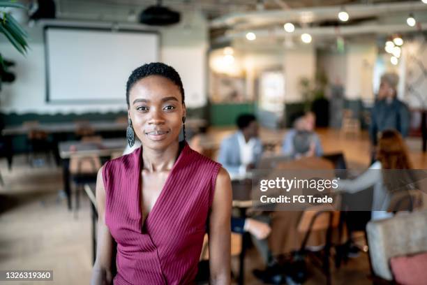 retrato de una joven empresaria con compañeros de trabajo de fondo - fundador fotografías e imágenes de stock