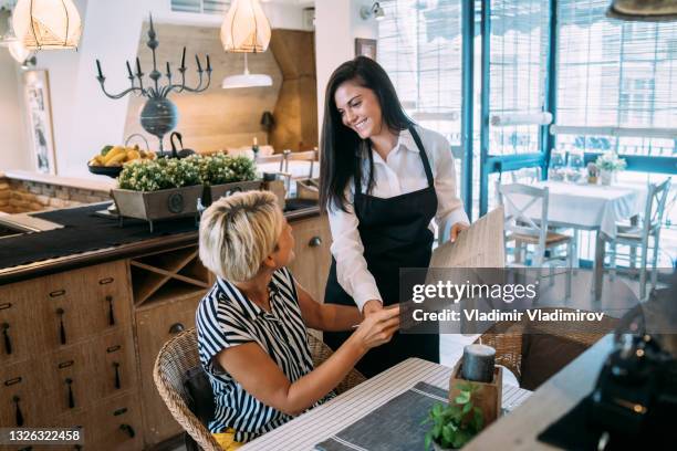 cameriera che aiuta un cliente a scegliere una cena - waitress foto e immagini stock