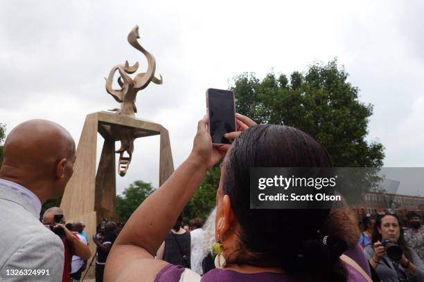 Michelle Duster takes a photo at the dedication of a monument to her great-grandmother, journalist, educator, and civil rights leader, Ida B. Wells...