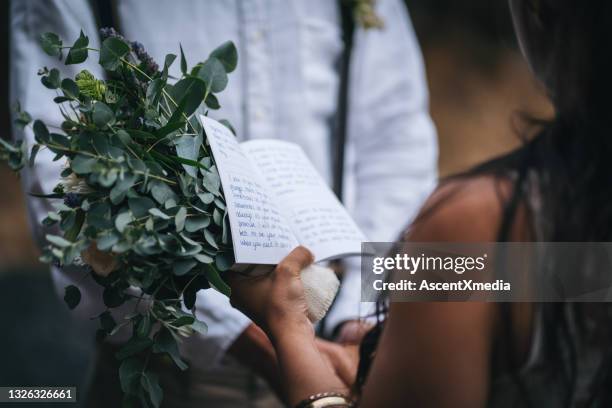 young couple marry on rocky beach in wedding dress - trouwgelofte stockfoto's en -beelden