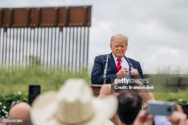 Former President Donald Trump pulls out his notes before speaking during a tour to an unfinished section of the border wall on June 30, 2021 in...