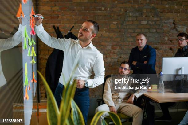 placing the adhesive note on a whiteboard. - team building stock pictures, royalty-free photos & images