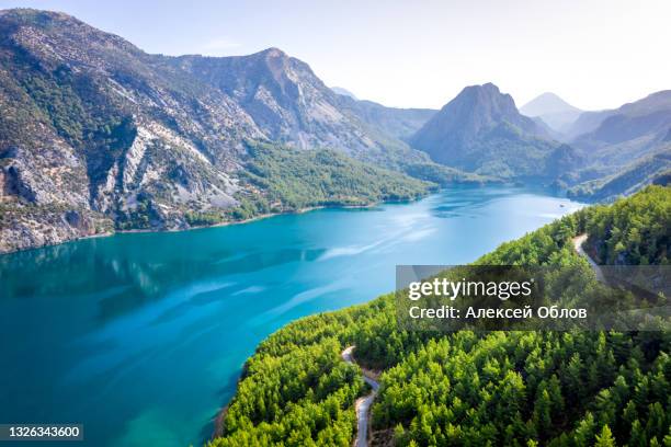 dam lake in green canyon. beatiful view to taurus mountains and turquoise water. coniferous forest with bright green pine trees and a road stretching into the distance. manavgat, turkey - manavgat stock pictures, royalty-free photos & images