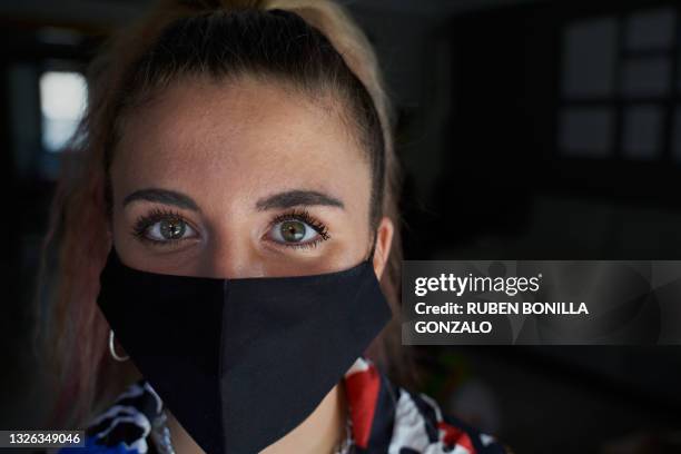 front view of caucasian young girl with expressive green eyes smiling behind a covid-19 fabric mask. - cloth face covering mask stock pictures, royalty-free photos & images