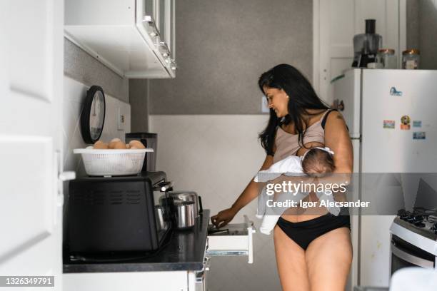 mother breastfeeding in the kitchen - postpartum-mother stock pictures, royalty-free photos & images