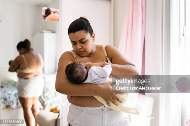 mother breastfeeding in the bedroom - latin american and hispanic ethnicity newborn stock pictures, royalty-free photos & images