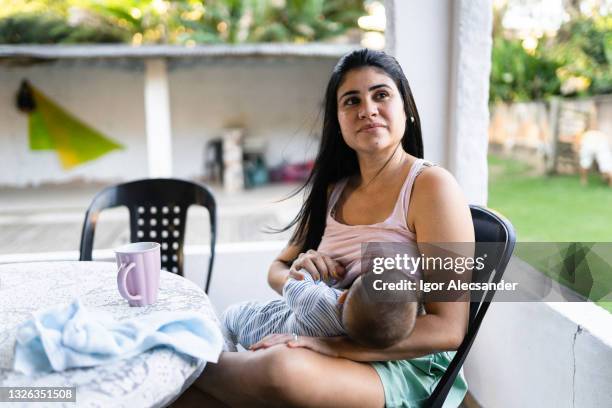 breastfeeding in the backyard - latin american and hispanic ethnicity newborn stock pictures, royalty-free photos & images