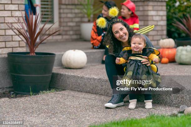 mom and baby in matching bumblebee halloween costumes - parents baby sister stock pictures, royalty-free photos & images