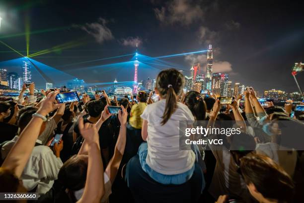 People watch a light show to celebrate the 100th anniversary of the founding of the Communist Party of China at The Bund on June 30, 2021 in...