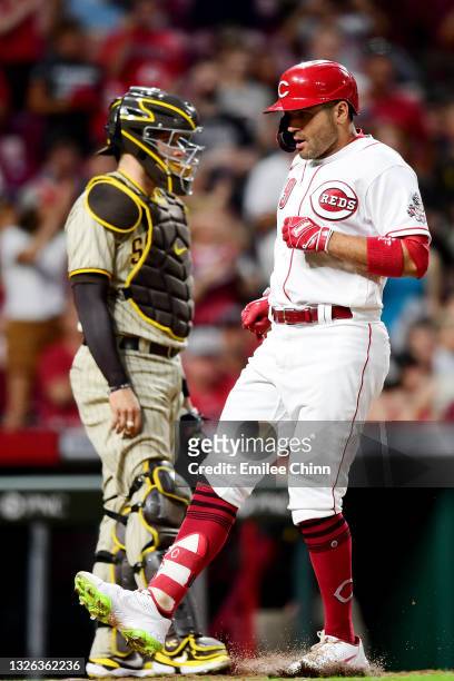 Joey Votto of the Cincinnati Reds steps on home plate after hitting a solo home run in the third inning for his 1000th career RBI during their game...