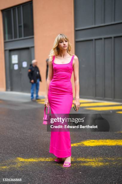 Singer Angele Van Laeken wears a low-neck square neck sleeveless long neon pink dress, a neon pink leather Jacquemus bag, pink sandals shoes, during...