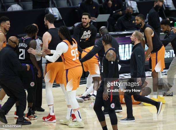 Patrick Beverley of the LA Clippers is held back after pushing Chris Paul of the Phoenix Suns to the ground during the second half in Game Six of the...