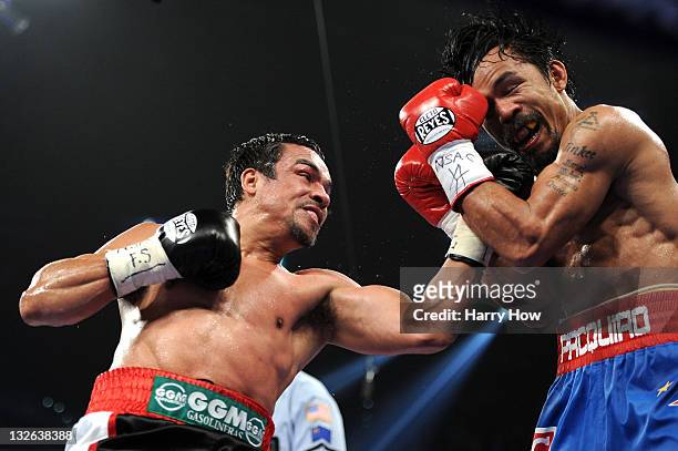 Juan Manuel Marquez throws a left to the face of Manny Pacquiao during the WBO world welterweight title fight at the MGM Grand Garden Arena on...