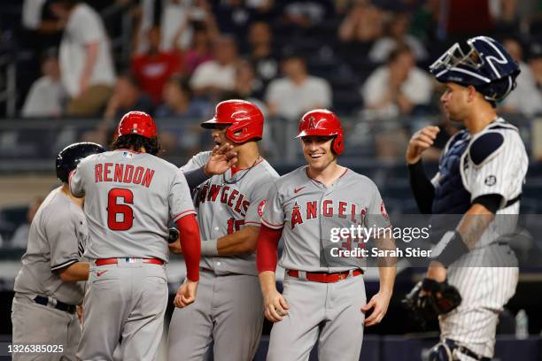 Anthony Rendon, Juan Lagares, and Max Stassi of the Los Angeles Angels celebrate after scoring on a grand slam to tied the game hit by Jared Walsh ,...