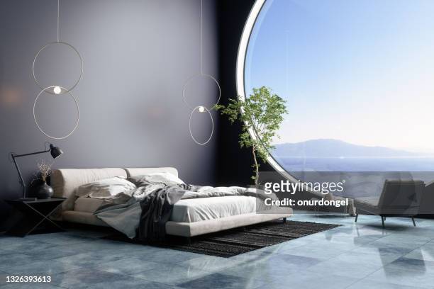 luxurious bedroom interior with messy bed and armchair in holiday villa or in hotel. seaview from the window. - hotelsuite stockfoto's en -beelden