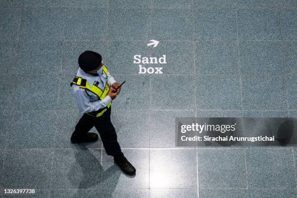 The sign "sandbox" is seen on the floor while a security guard patrol the arrival hall in preparation for international passengers from an Etihad...