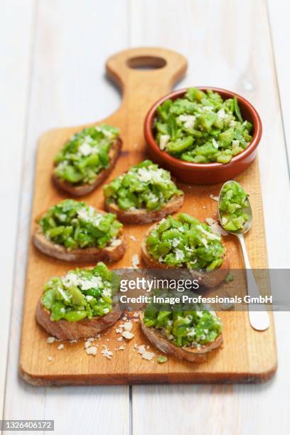 crostini topped with broadbeans, garlic and parmesan - crostini stock pictures, royalty-free photos & images