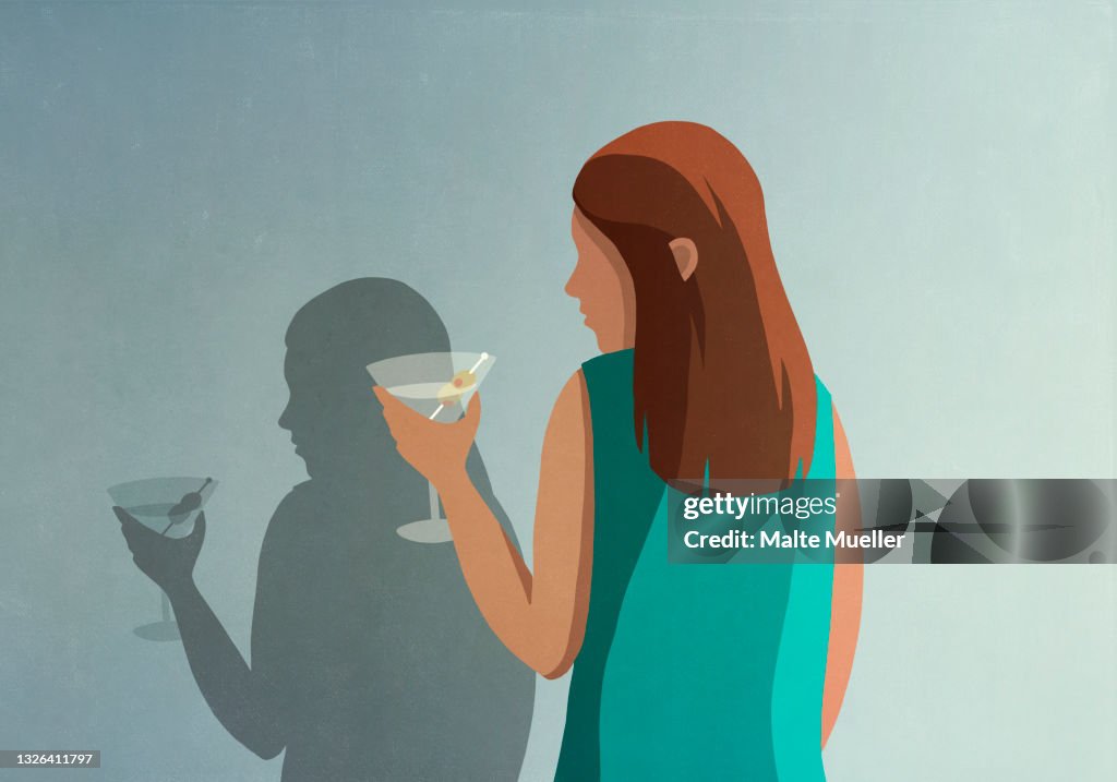Shadow of woman with martini at wall
