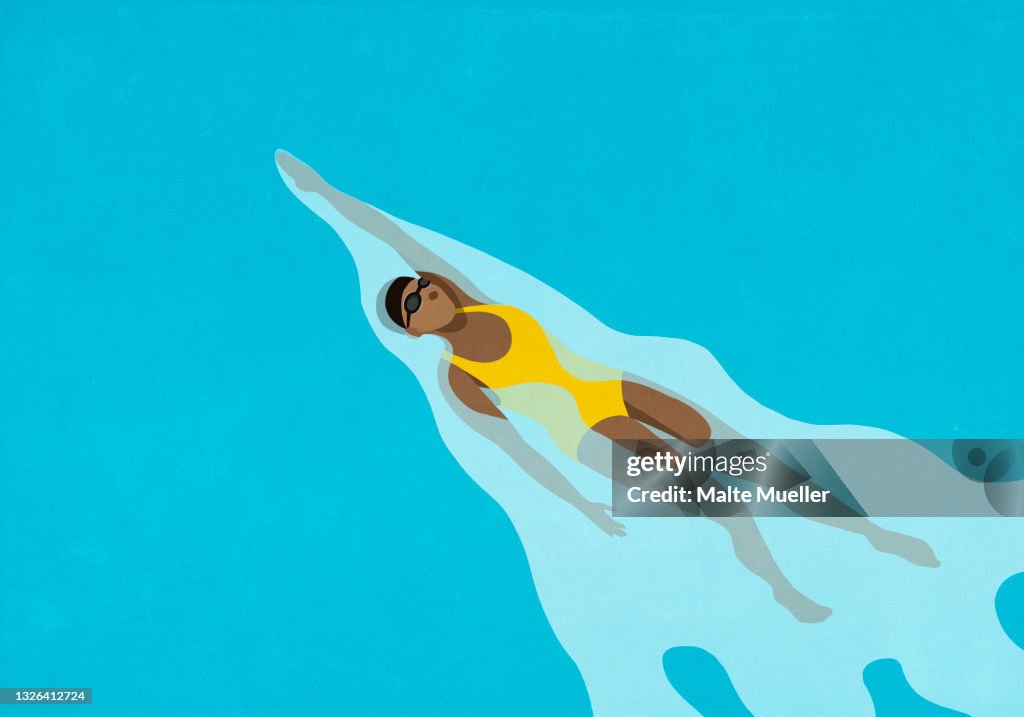 Woman swimming backstroke in water