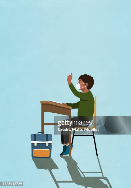 schoolboy in face mask raising hand at classroom desk - pandémie stock illustrations