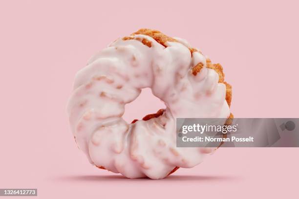 close up frosted pink cruller donut - buñuelo en forma de rosca fotografías e imágenes de stock