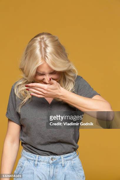 happy woman laughing on yellow background - sneeze stock pictures, royalty-free photos & images