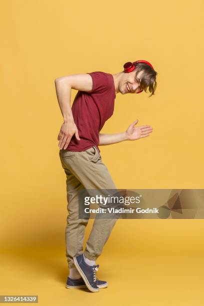 portrait playful young man with headphones dancing - headphones isolated foto e immagini stock