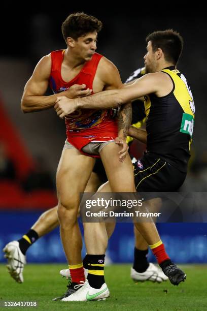 Trent Cotchin of the Tigers tackles Sean Lemmens of the Suns during the round 16 AFL match between the Gold Coast Suns and the Richmond Tigers at...