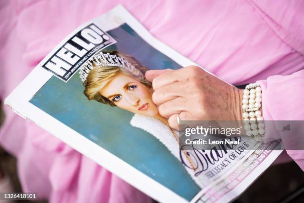 Royal fan Anne Daley holds a copy of Hello magazine on what would have been the 60th birthday of Princess Diana, at Kensington Palace on July 01,...