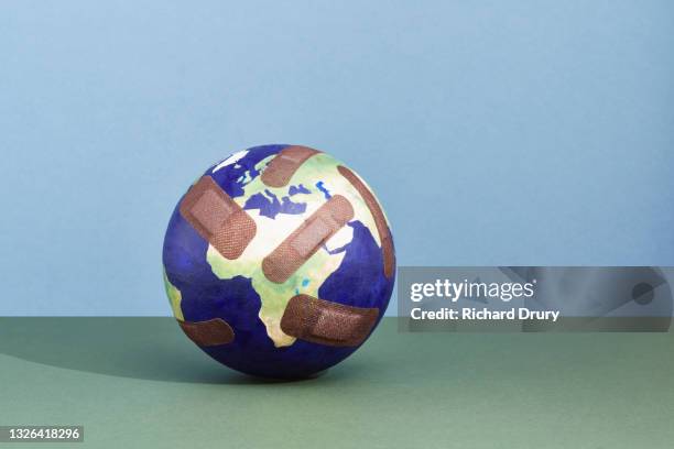 a world globe with band-aids - world aids stock pictures, royalty-free photos & images