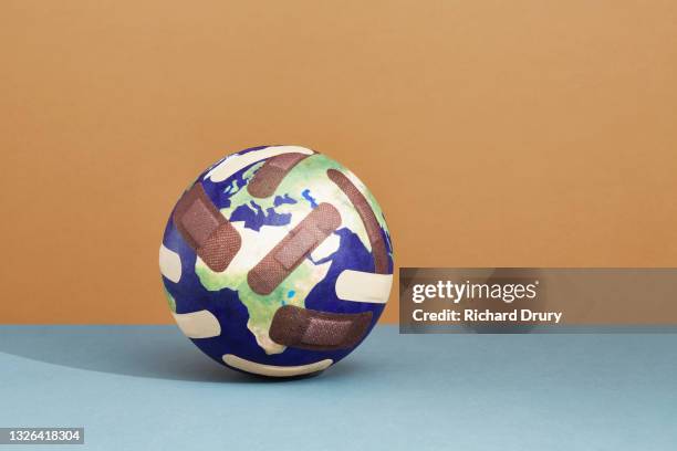 a world globe with band-aids - world aids stock pictures, royalty-free photos & images