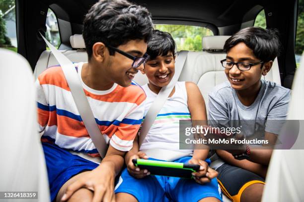 boys playing with digital tablets in car - boy playing with cars stock pictures, royalty-free photos & images