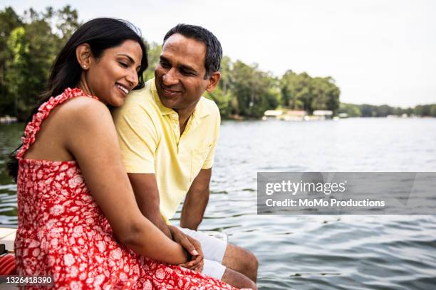 husband and wife sitting on dock at lake - ärmelloses kleid stock-fotos und bilder