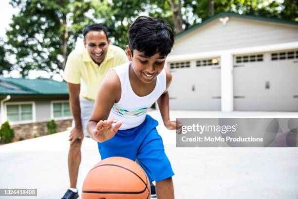 father and son playing basketball in driveway - indian family in their 40's with kids imagens e fotografias de stock