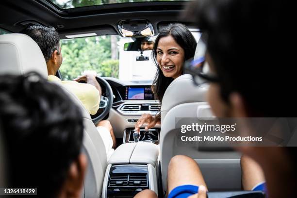 mother talking to children in car on road trip - driving photos et images de collection