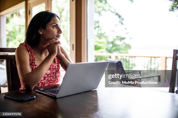 woman using laptop computer at home - indian lifestyle stock-fotos und bilder