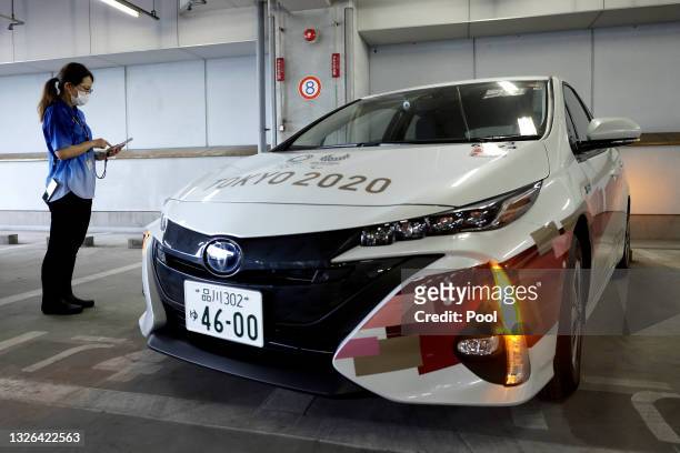 Staff member uses an smartphone app for drivers to unlock Toyota Motor Corp. Mirai fuel cell electric vehicle during a demonstration of the transport...