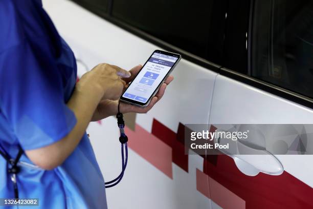 Staff member uses an smartphone app for drivers to unlock a Toyota Motor Corp. Mirai fuel cell electric vehicle during a demonstration of the...