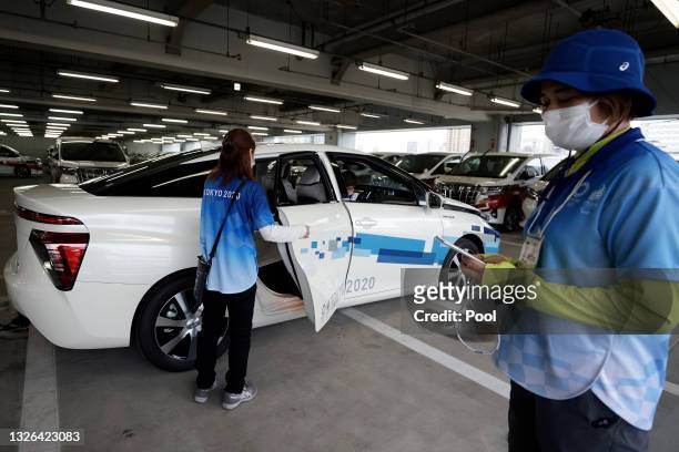 Staff member, left, gets into a Toyota Motor Corp. Mirai fuel cell electric vehicle during a demonstration of the transport operation support system...