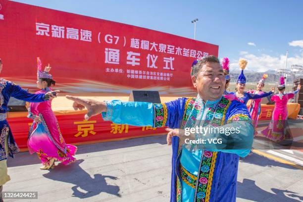 People dance during opening ceremony of the last section of the 2,822-kilometer Beijing-Urumqi Expressway, the longest desert-crossing expressway in...