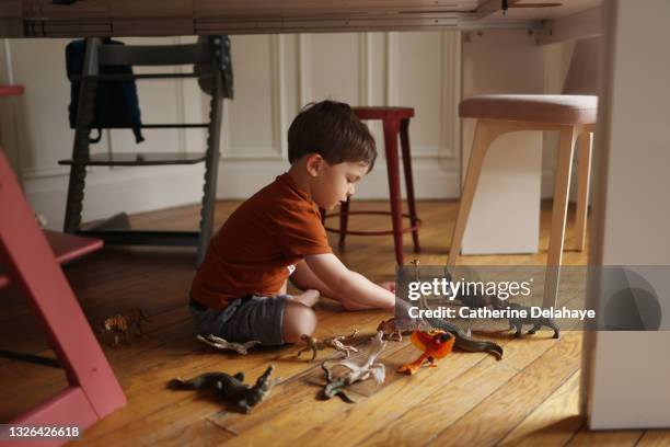 a 3 year old little boy at home - sitting on ground stock-fotos und bilder