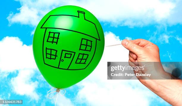 man pricking balloon, inflated house prices - housing problems stock-fotos und bilder