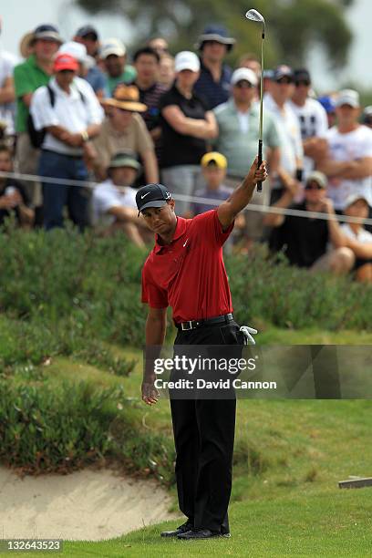 Tiger Woods of the USA chips in for an eagle 3 on the par 5, 14th hole during day four of the 2011 Emirates Australian Open at The Lakes Golf Club on...