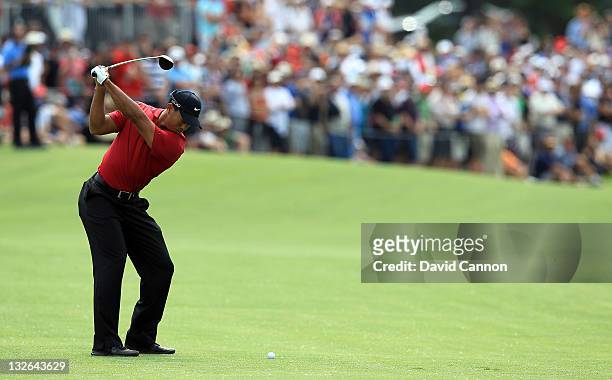 Tiger Woods of the USA plays his third shot on the par 5, 11th hole during day four of the 2011 Emirates Australian Open at The Lakes Golf Club on...