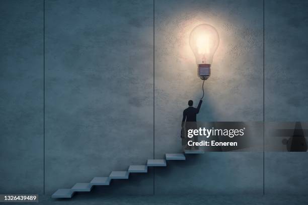 concetto di idea creativa - lampadina che si accende foto e immagini stock