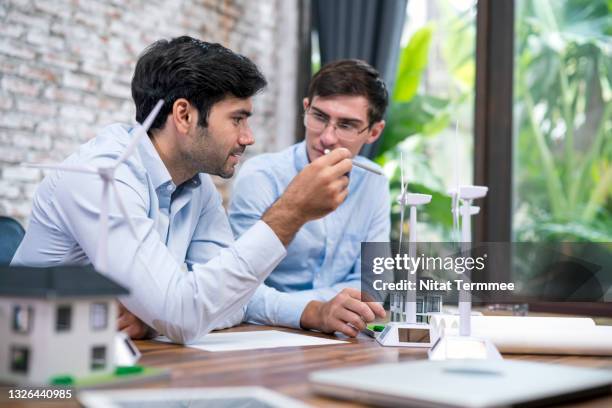 sustainable architectural design and green building concepts.  project architect engineers having a discussion and exchange ideas of the architectural design structure of wind and solar energy in a business office. - building dedication stock pictures, royalty-free photos & images