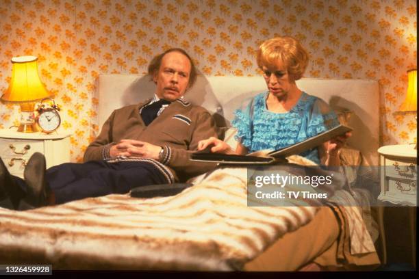 Actors Brian Murphy and Yootha Joyce lying in bed as their characters George and Mildred Roper in sitcom series George And Mildred, circa 1979.