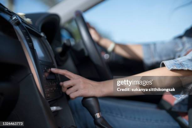 cropped hand of woman turn on radio in the car. - auto musik stock-fotos und bilder