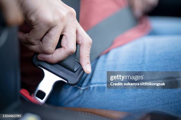 car safety concept; close up of hand woman pulling seat belt in her car. - schnalle stock-fotos und bilder