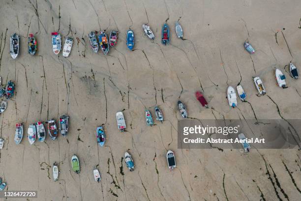 drone shot looking down on multiple boats stranded during low tide, cornwall, united kingdom - abandoned boat stock pictures, royalty-free photos & images